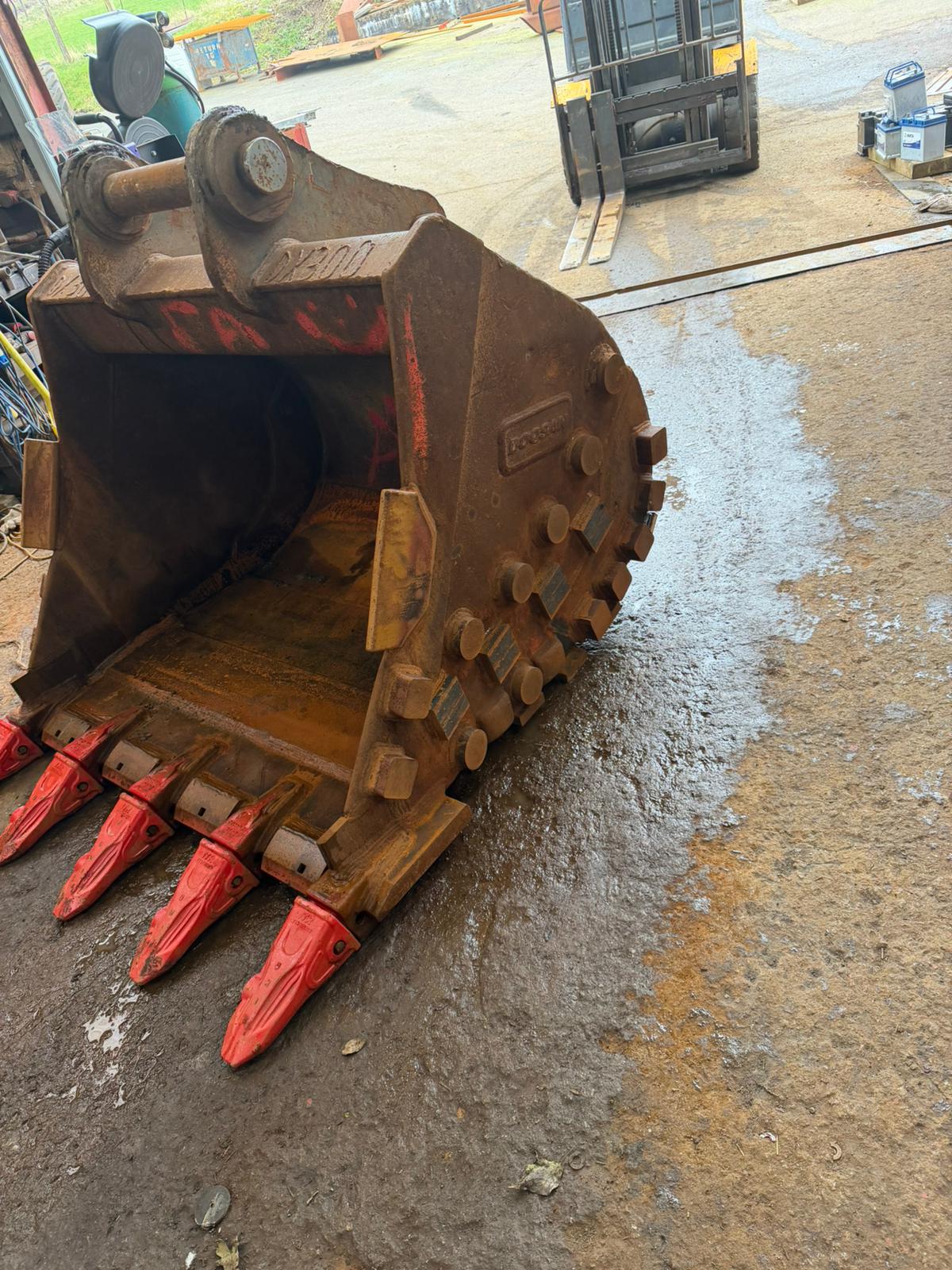 Rock bucket with orange Esco teeth